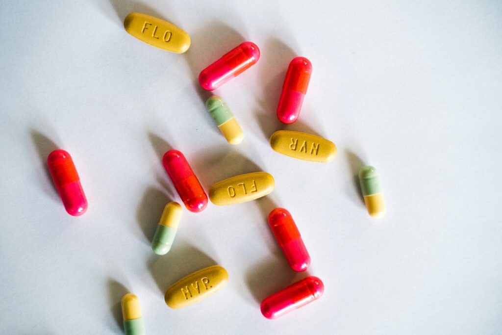 A vibrant assortment of colorful capsules and pills scattered on a white surface.